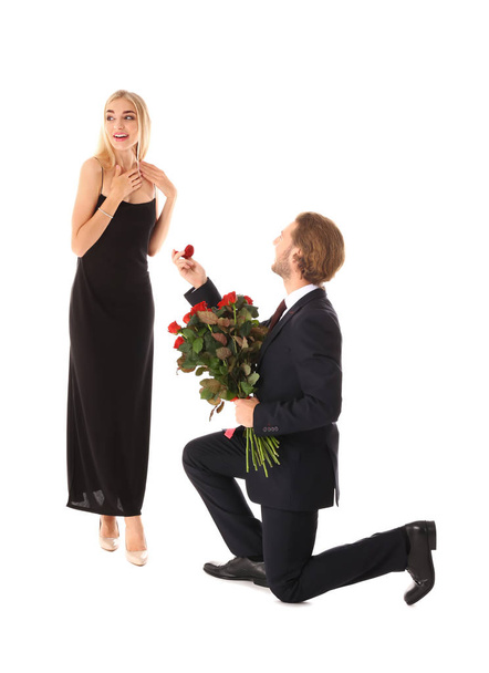 Young man proposing to his beloved on white background - Foto, Imagem