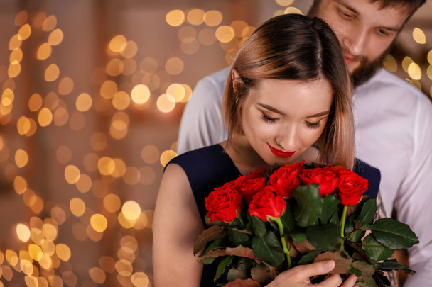 Loving young couple with bouquet of beautiful flowers on romantic date - Φωτογραφία, εικόνα