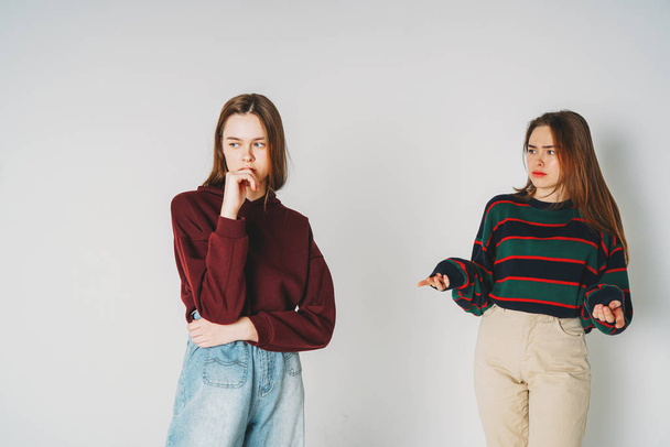 Due sorelle gemelle belle ragazze hipster in abbigliamento casual su sfondo grigio isolato, litigio, risentimento
 - Foto, immagini