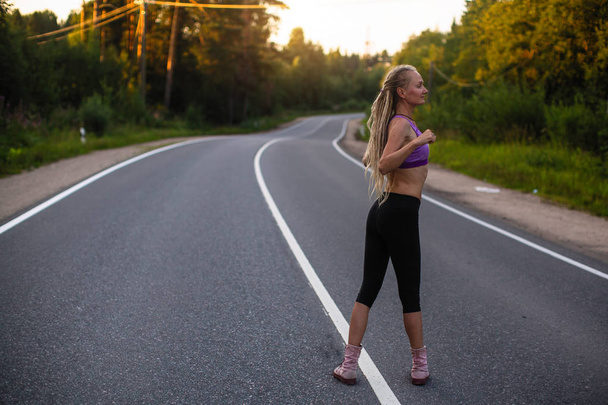 Uruchomione kobiety rozgrzeje przed jogging na drogach podmiejskich.  - Zdjęcie, obraz
