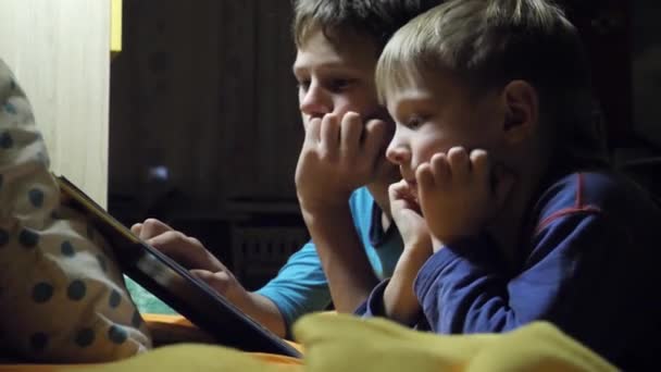 children read a book in bed at night. - Video, Çekim