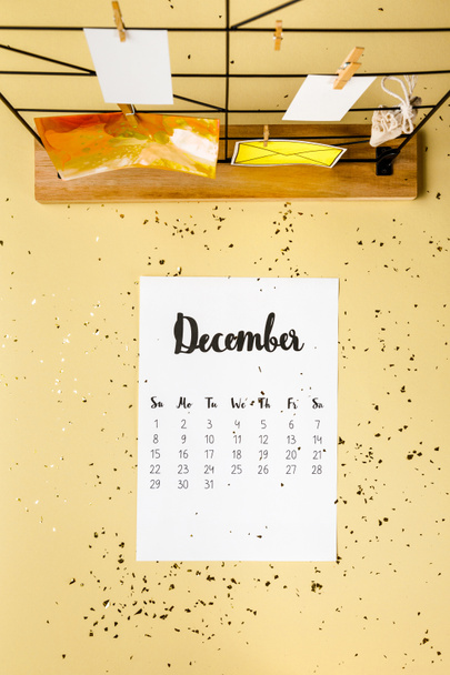 top view of december calendar with golden confetti and cards with clothespins on beige - Φωτογραφία, εικόνα