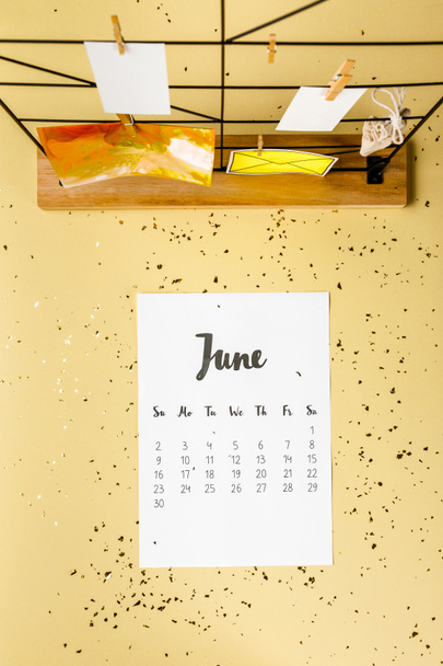 top view of june calendar with golden confetti and cards with clothespins on beige - Φωτογραφία, εικόνα