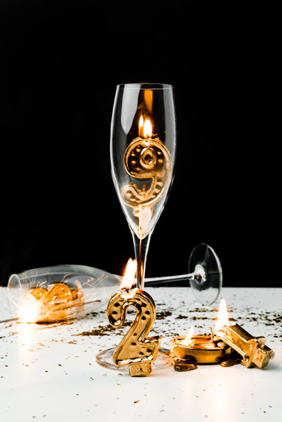 wine glasses and golden 2019 numbers with candles on black   - Fotoğraf, Görsel
