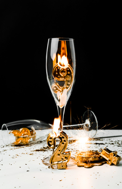 verres à champagne avec bougie, étincelant et doré 2019 chiffres sur noir
  - Photo, image