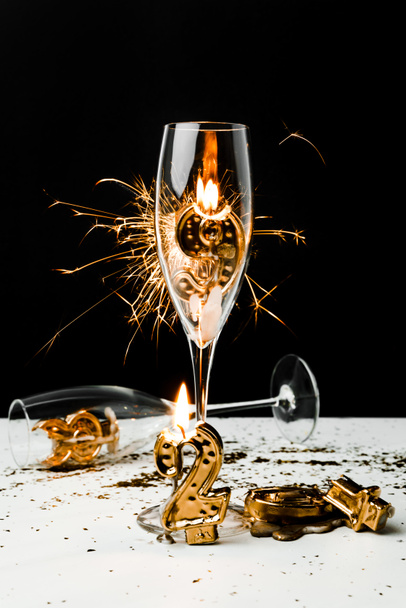 champagne glasses, sparkler and golden 2019 numbers on black    - Photo, Image
