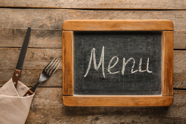 Menu board with cutlery on wooden table - Foto, Imagen