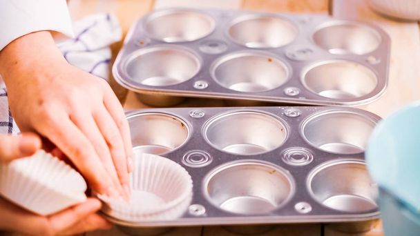 Futter Metall-Muffin-Pfanne mit Papier-Cupcake-Liner, um Blaubeer-Muffins zu backen. - Foto, Bild