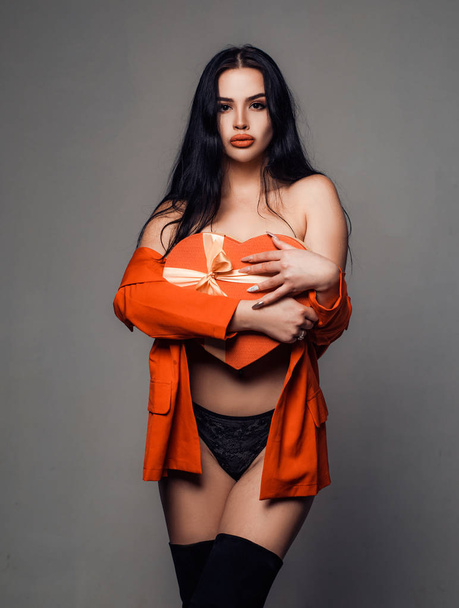 Romantic Gifts and Valentines Gift Ideas. Sexy brunette woman in red lingerie holding heart. - Valokuva, kuva
