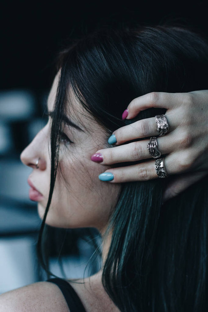 Side view of young woman with silver rings on hand - Foto, immagini