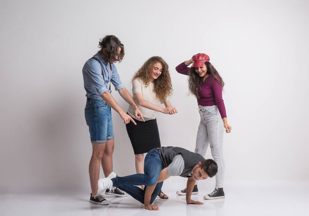 A group of young people with a friend dancing breakdance in a studio. - Foto, Imagem