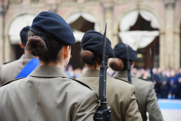 Detail s uniformovaný ženy stojící během vojenské ceremonie v Bologna, Itálie. V popředí, Žena pohledu zezadu s puška bajonet. - Fotografie, Obrázek