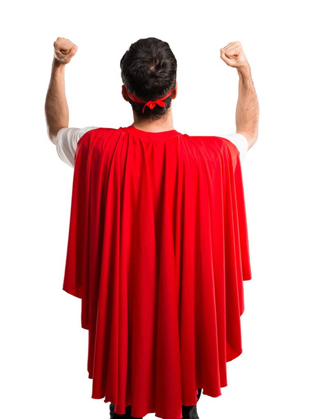 スーパー ヒーロー マスクと赤マントは勝利を祝う男し、分離の白い背景の成功にはビックリ - 写真・画像