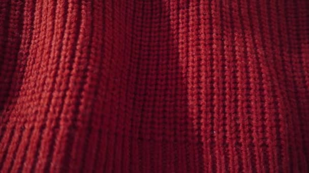 Gedetailleerde shot van een rode gebreide trui. Kan worden gebruikt als achtergrond. - Video