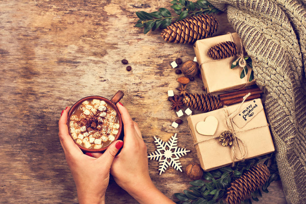 A woman's hand holds a cup. Gift, cones, gifts, coffee, cocoa. Christmas, New Year background.  Winter, New Year, Christmas still life.  - Foto, Bild