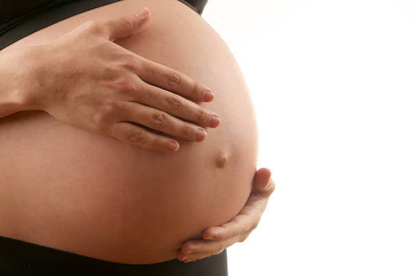 έγκυος γυναίκα χαϊδεύει την κοιλιά με λευκό φόντο - Φωτογραφία, εικόνα