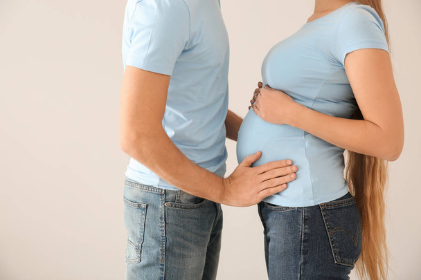 молода вагітна пара на світлому фоні
 - Фото, зображення