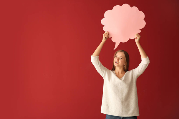 Young woman with blank speech bubble on color background - Photo, Image