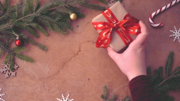 mano humana poniendo regalo de Navidad sobre la mesa
 - Metraje, vídeo