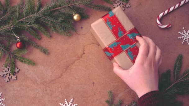emberi kéz, amivel a karácsonyi ajándékot az asztalon - Felvétel, videó