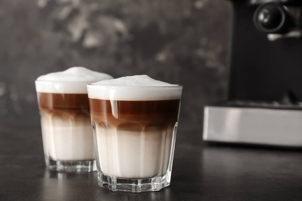 Glasses of tasty aromatic latte on dark table - Фото, изображение