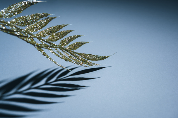 selektiver Schwerpunkt des festlichen Zweiges mit goldenem Glanz und Schatten, weihnachtliches Hintergrundkonzept - Foto, Bild