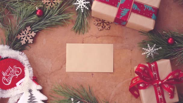 Happy Christmas concept with pine tree branches, gift boxes and hand putting blank card on table - Footage, Video