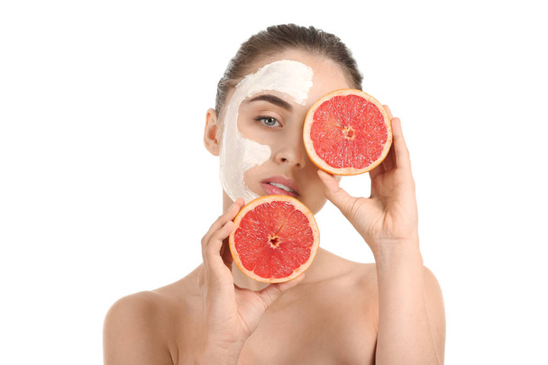 Beautiful young woman with facial mask and grapefruit on white background - Foto, afbeelding
