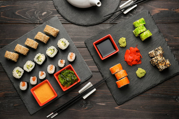 Placas de pizarra con diferentes juegos de sushi en la mesa de madera
 - Foto, Imagen