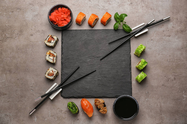 Piatto di ardesia con diversi set di sushi sul tavolo grigio
 - Foto, immagini