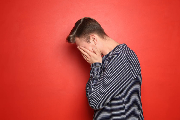 Portrait of stressed young man on color background - Photo, Image