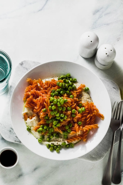 gluten-free healthy vegan red lentil pasta with green peas and cauliflower puree with garlic. tasty mac and cheese fusilli  for celiac disease - Fotó, kép