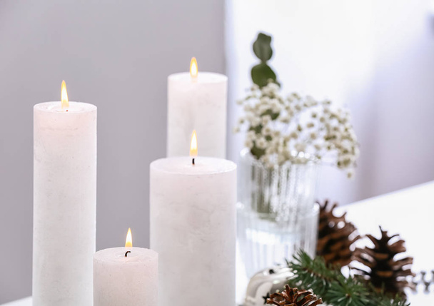 schöne brennende Kerzen mit Weihnachtsdekor auf dem Tisch - Foto, Bild