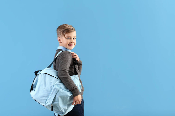 niedlichen kleinen Schuljungen mit Rucksack auf farbigem Hintergrund - Foto, Bild