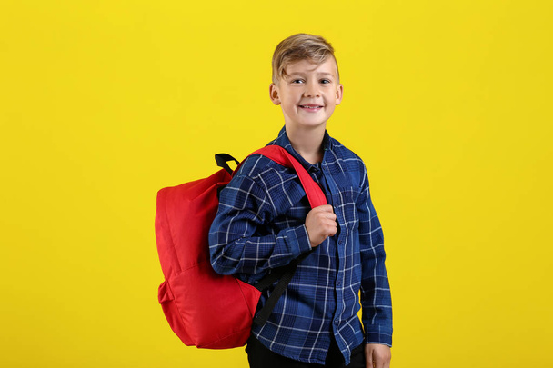 Cute little schoolboy with backpack on color background - Fotografie, Obrázek