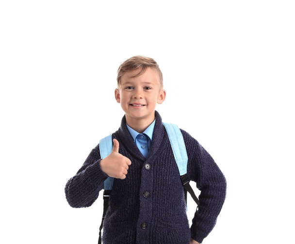 Cute little schoolboy with backpack showing thumb-up on white background - Photo, Image