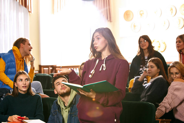De groep van vrolijke gelukkig studenten zitten in een collegezaal vóór de les - Foto, afbeelding