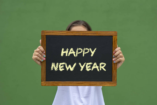 bir tahta ile mesaj mutlu yeni yıl writte tutan kız - Fotoğraf, Görsel
