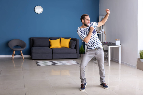 Красивий молодий чоловік танцює вдома
 - Фото, зображення