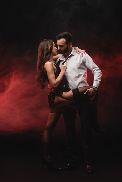 vášnivé milující pár objímat v červené zakouřené místnosti  - Fotografie, Obrázek