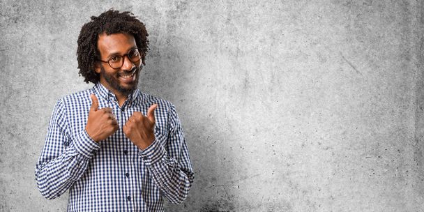 Hombre afroamericano negocios guapo alegre y emocionado, sonriendo y levantando el pulgar hacia arriba, concepto de éxito y aprobación, ok gesto
 - Foto, imagen