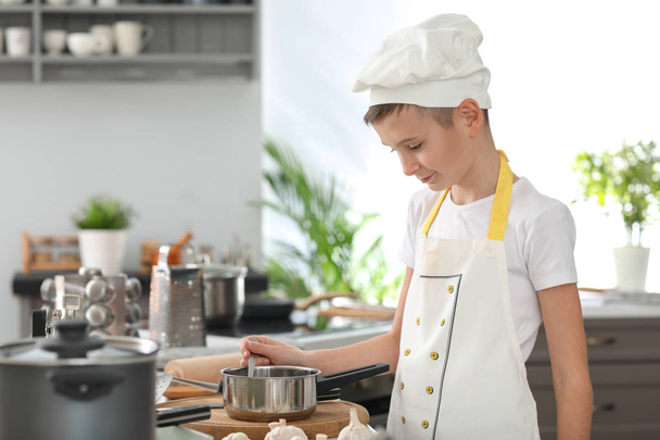 Cute little chef cooking in kitchen - Foto, Bild