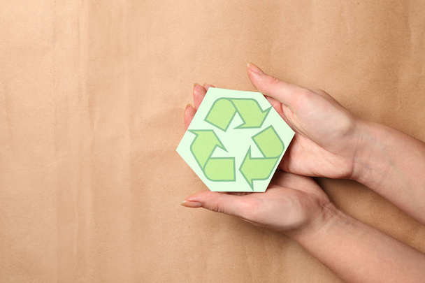 Manos femeninas con símbolo de reciclaje sobre fondo de color
 - Foto, Imagen