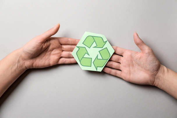 Female hands with recycling symbol on light background - Photo, image