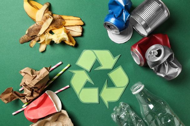 Recycling symbol and different garbage on color background - Photo, Image