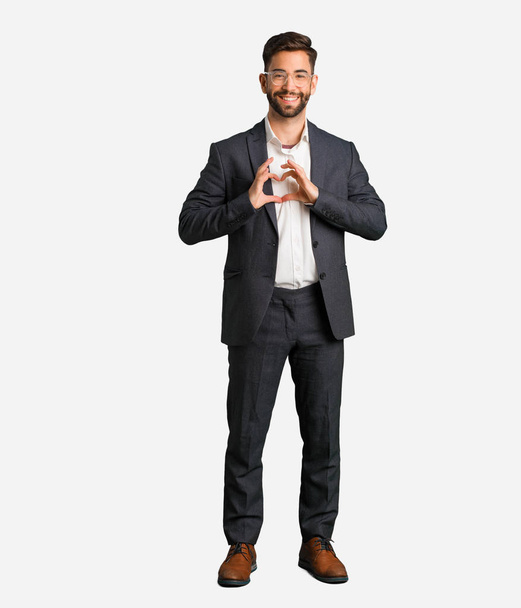 Young handsome business man doing a heart shape with hands - Photo, Image