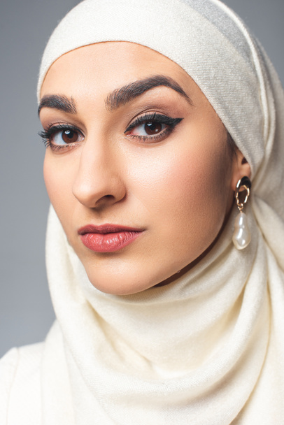 portrait of beautiful young muslim woman looking at camera isolated on grey  - Valokuva, kuva