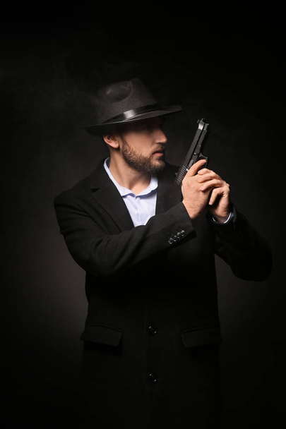 Detektiv mit Waffe auf dunklem Hintergrund - Foto, Bild