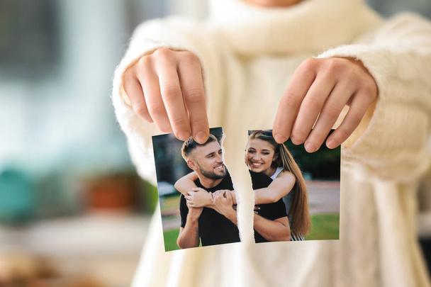 Woman tearing up photo of happy couple, closeup. Concept of divorce - Photo, Image