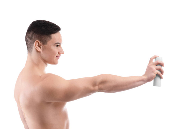 Jonge man met deodorant op witte achtergrond - Foto, afbeelding